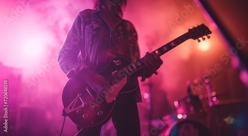 a person plays an electric guitar in front of a bright light
