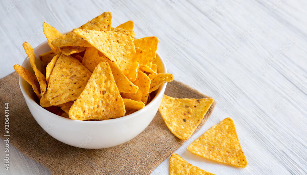Corn chips nachos on white bowl, isolated on white background, copyspace on a side Corn chips nachos on white bowl, isolated on white background, copyspace on a side