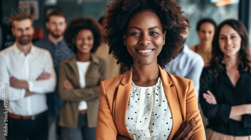 confident woman is standing in the foreground with a group of diverse people blurred in the background