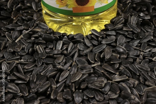 Fotografie A plastic bottle with vegetable oil stands on sunflower seeds.