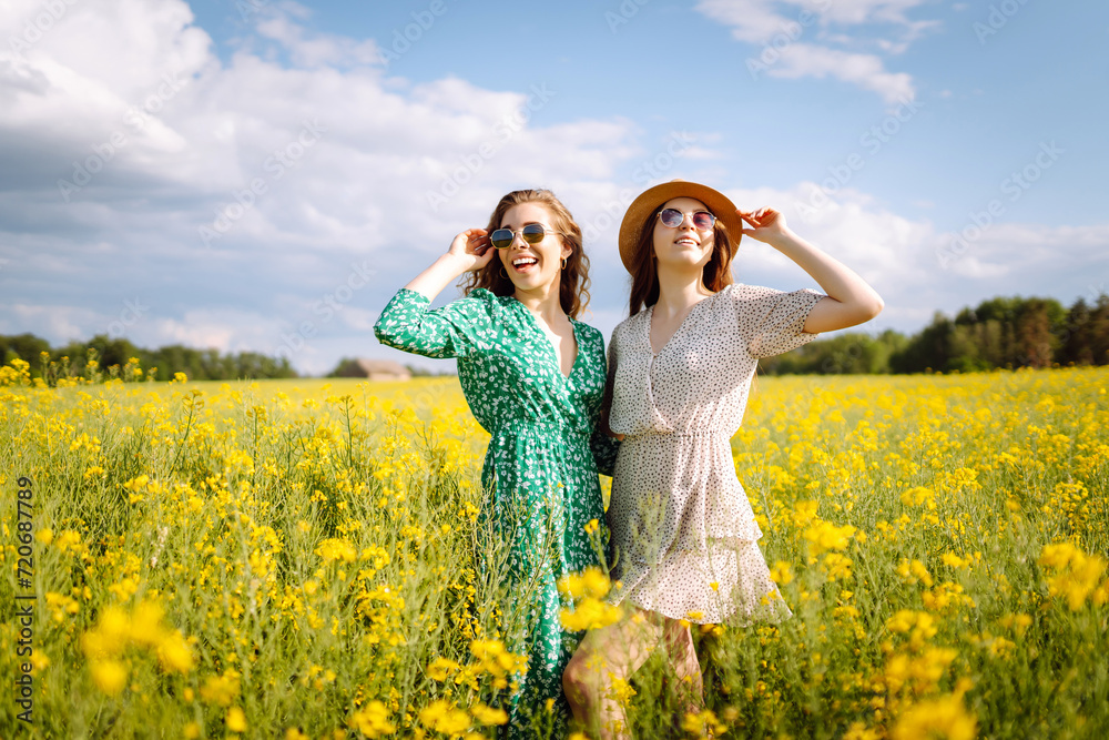Two Beautiful women in the blooming field. Nature, vacation, relax and lifestyle. Summer landscape. Two Beautiful women in the blooming field. Nature, vacation, relax and lifestyle. Summer landscape.