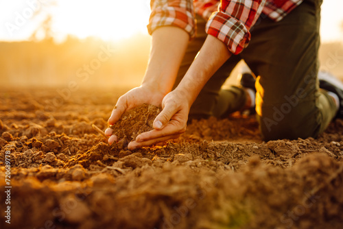 Male hands touching soil on the field. Expert hand of farmer checking soil health before growth a seed of vegetable or plant seedling. Concept of agriculture, business and ecology.
