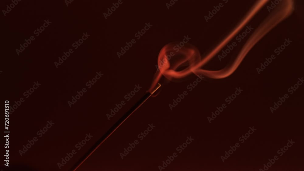 Smoke incense stick close-up on a dark background Smoke incense stick close-up on a dark background