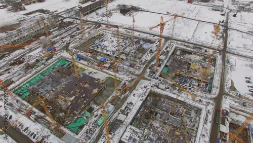 Panorama of construction site with many cranes on territory of factory photo