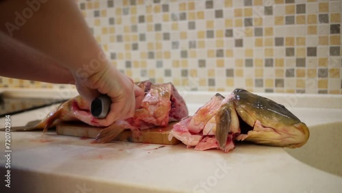 Woman hand cutting carp on pieces on board with champ sound.