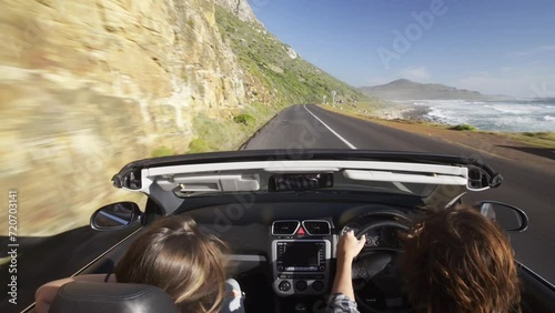 Couple, driving in car and road trip by beach for adventure, holiday vacation and sightseeing on mountains. Back of people or driver in speed, fast convertible or luxury transport for travel journey photo
