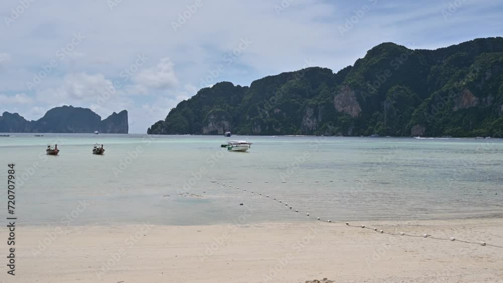 Sea view landscape with tropical Phi-Phi island, Thailand. Boats by the sea line. Blue clouds in sunny day by the sea. Travel and vacation in Thailand, Asia Sea view landscape with tropical Phi-Phi island, Thailand. Boats by the sea line. Blue clouds in sunny day by the sea. Travel and vacation in Thailand, Asia