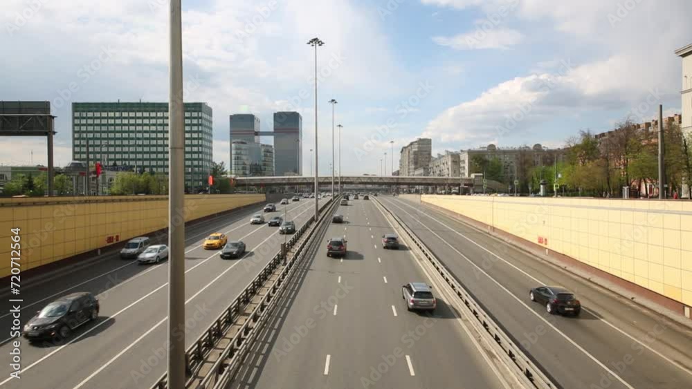 Cars go on highway with overpass in city at sunny day Cars go on highway with overpass in city at sunny day