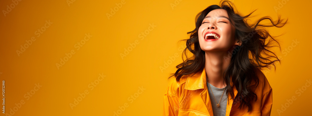 Asian model banner with smiling gesture and yellow jacket on a yellow background Asian model banner with smiling gesture and yellow jacket on a yellow background