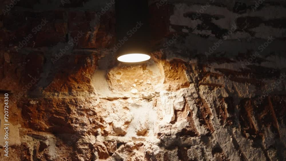 Vidéo Stock A warm spotlight illuminates a section of an exposed brick ...