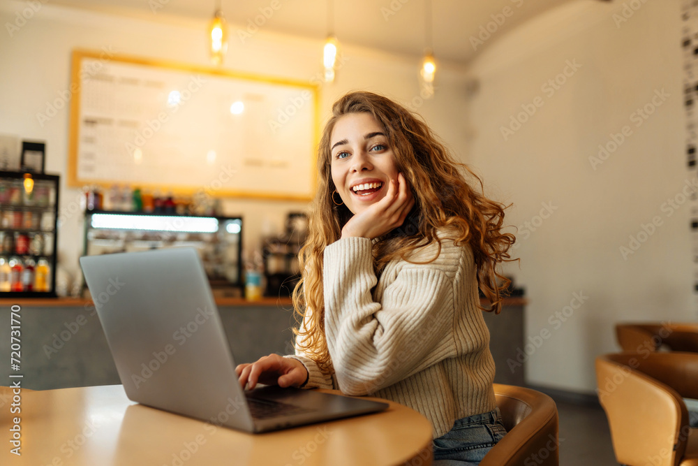 Happy woman sitting on cafe with laptop. Concept for education, business, shopping, blog or freelance. Happy woman sitting on cafe with laptop. Concept for education, business, shopping, blog or freelance.