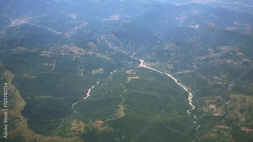 Winding river among green mountains, view from plane window Winding river among green mountains, view from plane window