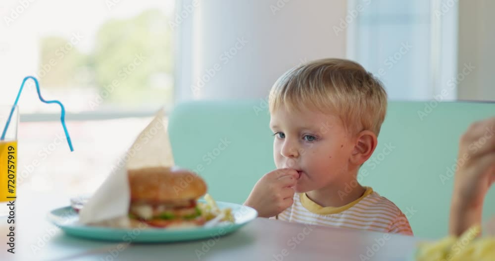Young Child Engaged in Eating French Fries Young Child Engaged in Eating French Fries