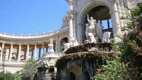 Water flows down the fountain with the statues in the Longchamp Palace