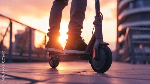Close up of man riding black electric kick scooter at cityscape at sunset photo