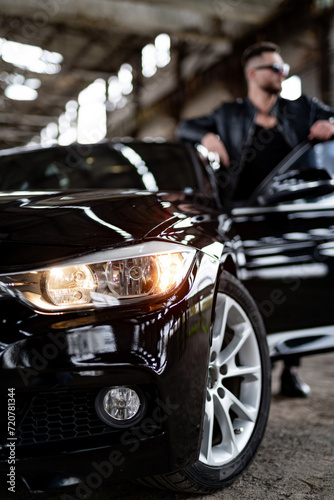 Man stands near black car in garage © Vadim
