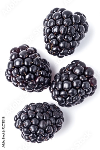Three blackberries are placed on a white surface. This image can be used for food photography or to illustrate the concept of fresh berries.