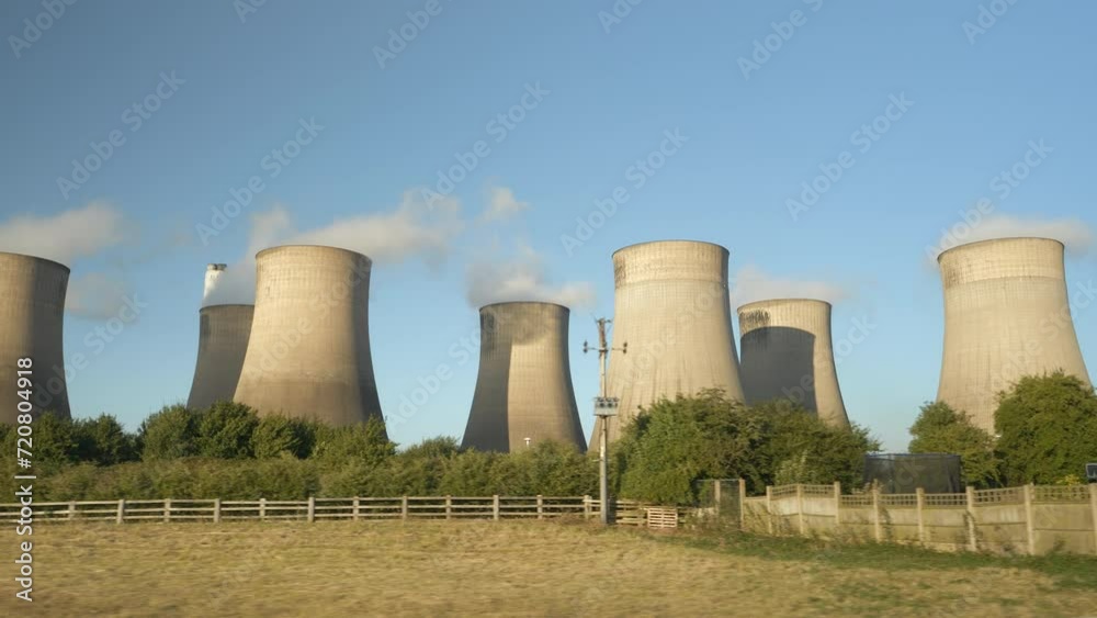 Driving past the huge cooling towers of thermal power plant in Ratcliffe On Soar. Concrete towers evaporate emissions from the production of electricity in one of the largest coal fired power plants Driving past the huge cooling towers of thermal power plant in Ratcliffe On Soar. Concrete towers evaporate emissions from the production of electricity in one of the largest coal fired power plants