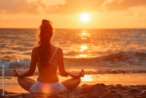 Woman practicing mantra yoga meditation outdoors on the beach at sunset achieving peaceful relaxation and spiritual well being She feels very concerned. © VisualProduction