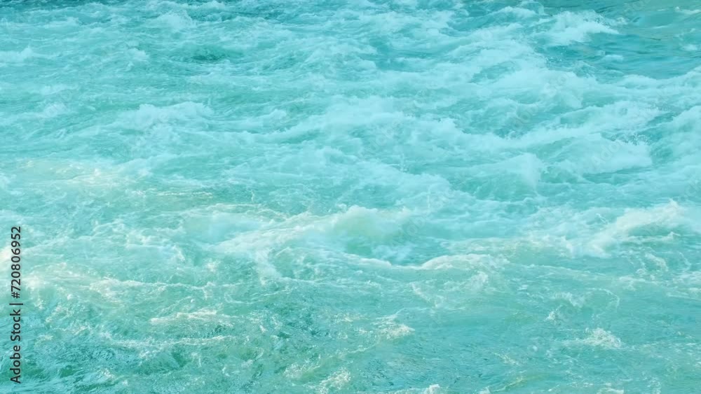 Rapidly seething stream of water. Big powerful river waves. White foam and water ripple. Foaming and splashing in the ocean. Strong flow of a mountain river. Blue clear water Rapidly seething stream of water. Big powerful river waves. White foam and water ripple. Foaming and splashing in the ocean. Strong flow of a mountain river. Blue clear water