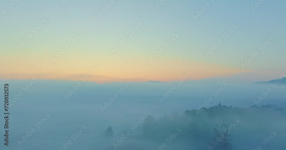Aerial view scenery beautiful sunrise above the sea of mist in front Thi Lor Su waterfall..There is a golden yellow glow on the horizon caused by the radiant light of the sun..colorful sky of sunrise Aerial view scenery beautiful sunrise above the sea of mist in front Thi Lor Su waterfall..There is a golden yellow glow on the horizon caused by the radiant light of the sun..colorful sky of sunrise
