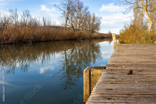 Riverside Tranquility: Wooden Pier under the Blue Sky.