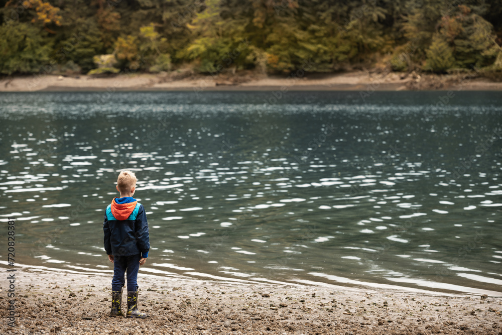child standing by the waters edge child standing by the waters edge