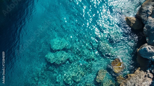 Sun-kissed rocks dot the aqua waters of the reef, inviting us to dive into the mesmerizing depths of the turquoise ocean