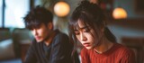 Depressed and frustrated young Asian couple facing relationship issues.