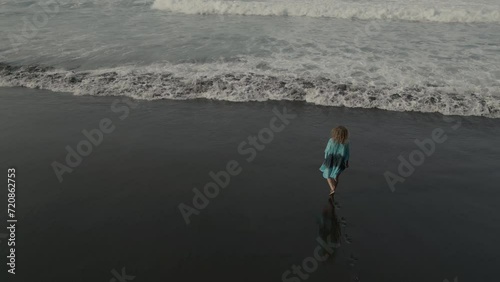 woman with blue dress walking on the beach
