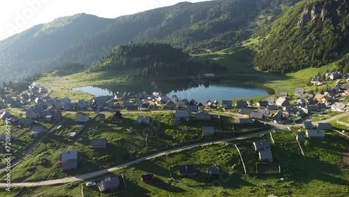 High drone view. Beautiful lake in the mountains in the morning with small wooden houses village. Prokosko lake, Bosnia and Herzegovina. 