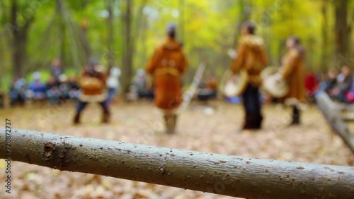 Animators in native suits performs for tourists at autumn day photo