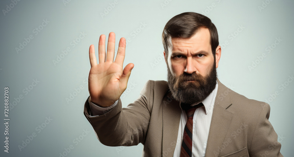 Businessman making stop gesture with his hand, on grey background. Businessman making stop gesture with his hand, on grey background.