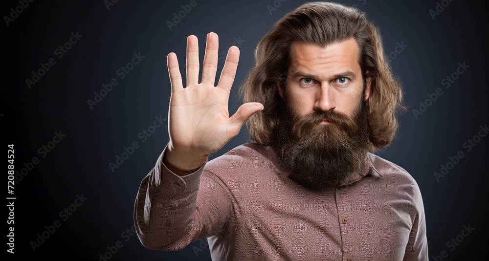young man with long beard and mustache on serious face making stop gesture on grey background young man with long beard and mustache on serious face making stop gesture on grey background