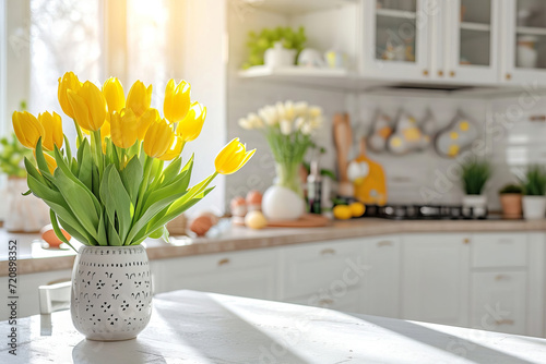 White kitchen decorated for Easter with yellow spring flowers and colored Easter eggs and copy space