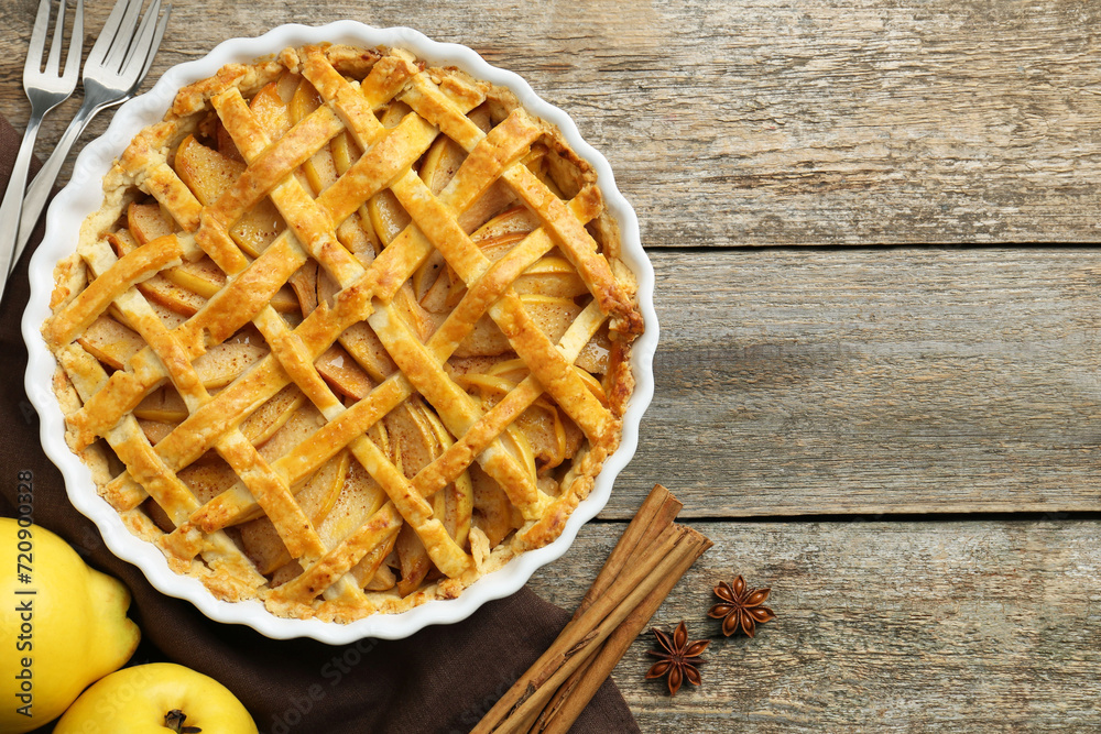 Tasty homemade quince pie served on wooden table, flat lay. Space for text Tasty homemade quince pie served on wooden table, flat lay. Space for text