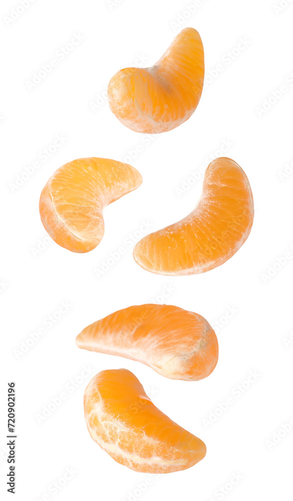 Pieces of fresh ripe tangerine falling on white background