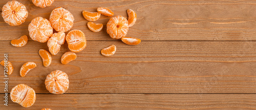 Sweet peeled tangerines on wooden background with space for text, top view