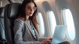 Business woman working with laptop at commercial airplane