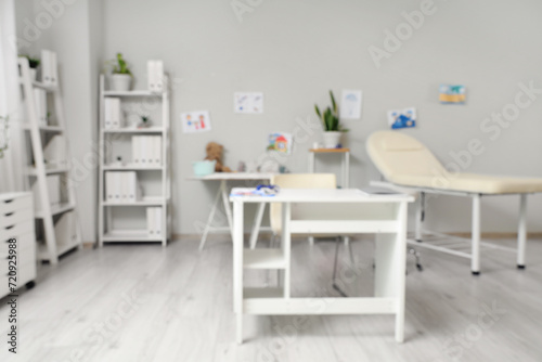 Blurred view of pediatrician's office with table, couch and children's drawings