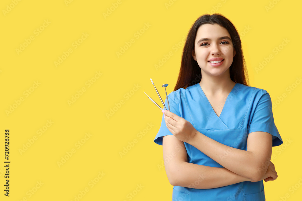 Female dentist with tools on yellow background. World Dentist Day Female dentist with tools on yellow background. World Dentist Day