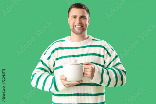 Young man with teapot on gr...
