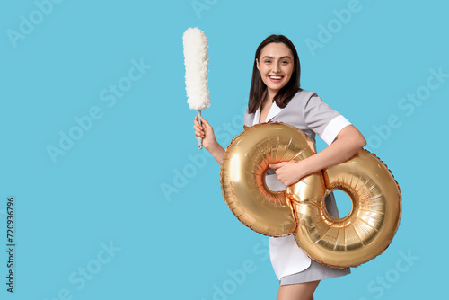 Smiling housekeeper holding...