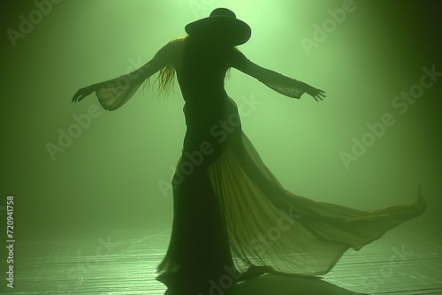 Silhouette d'une femme avec une capeline dansant sur fond vert photo