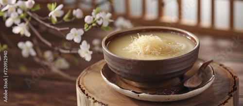 Bird's nest soup and edible bird's nest on a podium, with a plate and flower branch. Boosts collagen and moisturizes skin. photo