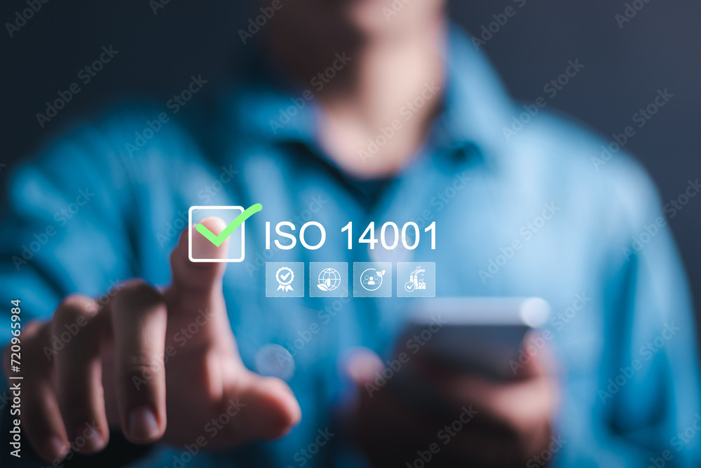 ISO 14001 concept. Businessman touching virtual screen of ISO 14001 certified for environmental management systems (EMS). Identify, control and reduce the environmental impact of activities. - obrazy, fototapety, plakaty 