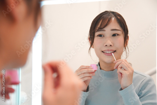 唇にワセリンを塗る女性 photo