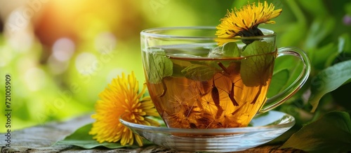 A cup of tea with dandelion roots and leaves in a glass. photo