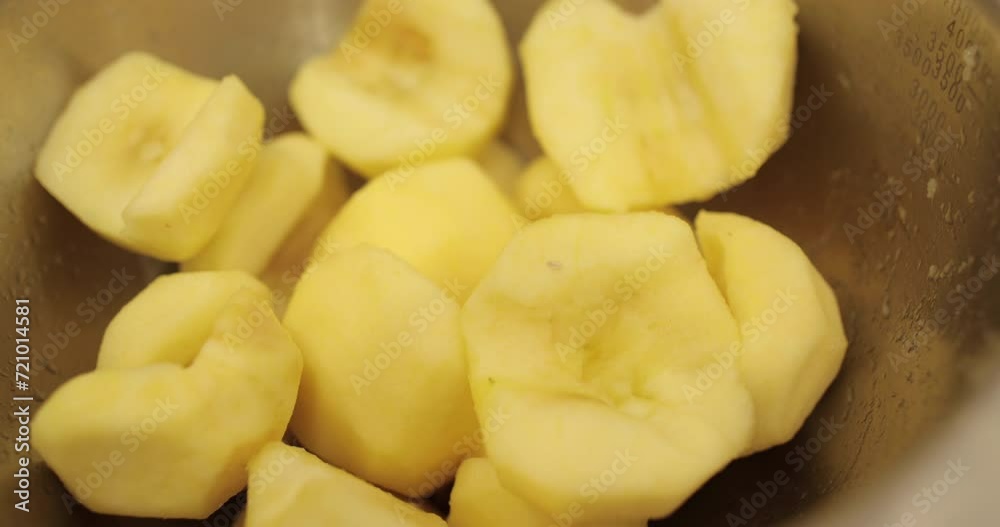 Peeled apples are stacked in a metal bowl in a professional kitchen in the process of preparing apple desserts Peeled apples are stacked in a metal bowl in a professional kitchen in the process of preparing apple desserts