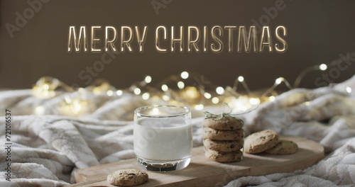 Merry christmas text over christmas cookies and milk with string lights in background